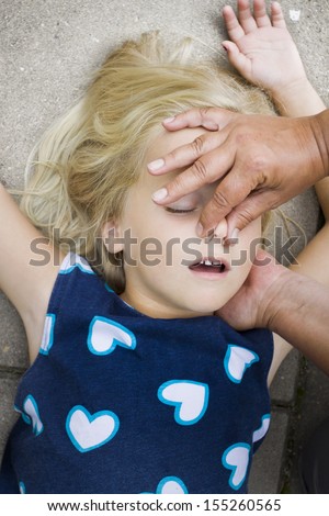 A little girl receiving mouth to mouth first aid by nurse or doctor or paramedic