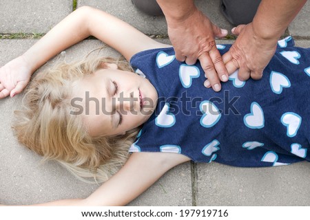 A little girl receiving first aid heart massage by nurse or doctor or paramedic
