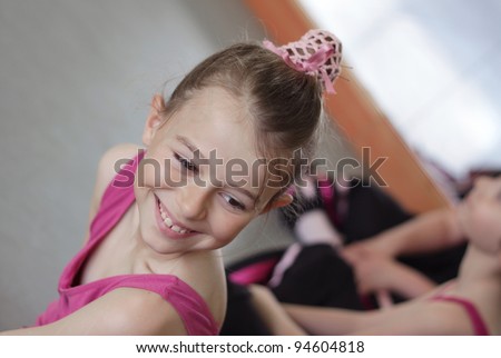 Young girl laughing with her friends during her ballet lesson