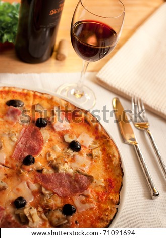 food, a pizza with a bottle of wine and wine glasse