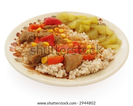 Pearl barley with pork and pepper goulash and low-salt pickles - isolated on white background