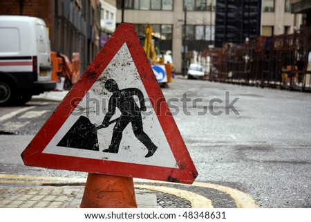Road works sign with road works in the background