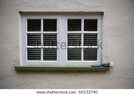 Window in a wall with a paint brush on the ledge