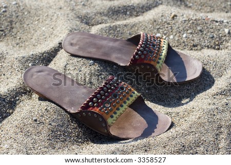 Summer lady leather slippers in beach sand