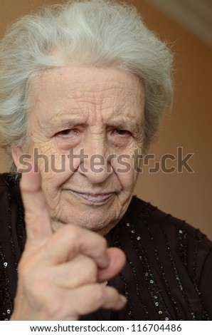 old woman with her finger up for admonition