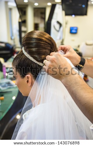 bride getting ready for wedding in hair dressing saloon