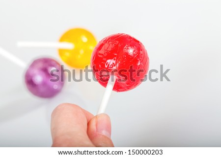 a hand holding red lolly pop