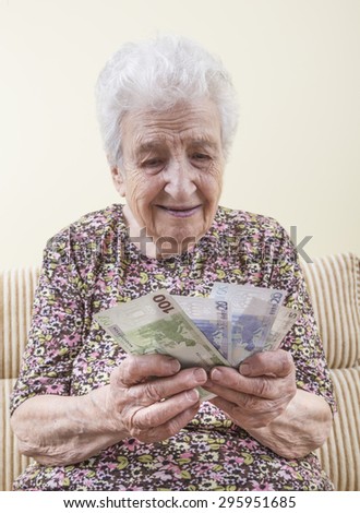 senior woman counting money (euros)