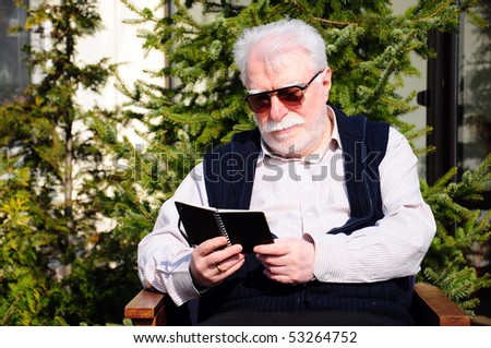 old man reading a book outdoor