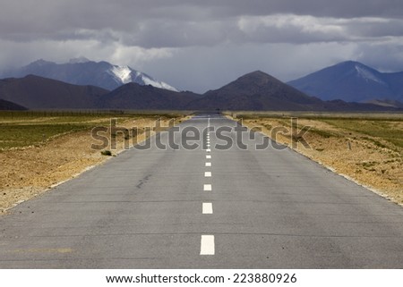 The straight road under white cloud in Tibet of China.
