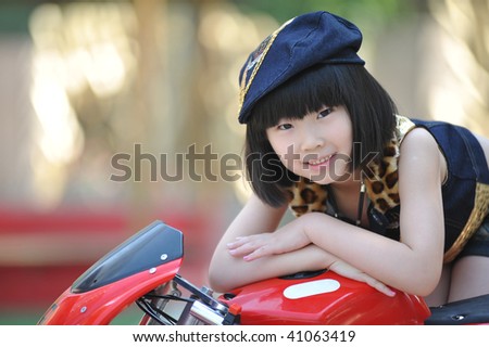 Adorable little girl on the red toy motorbike.