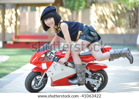 Adorable little girl on the red toy motorbike.