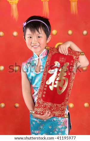 The little asian girl is in Chinese style clothes holding \