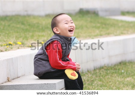 Little Chinese boy is laughing loudly