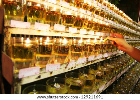 KUALA LUMPUR - MAY 18: A hand lights up candles during the celebration of Wesak day on May 18, 2008 in Kuala Lumpur, Malaysia. Wesak is informally called as Buddha\'s Birthday.