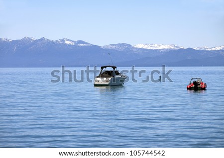 Power boats on lake tahoe with surrounding mountains.