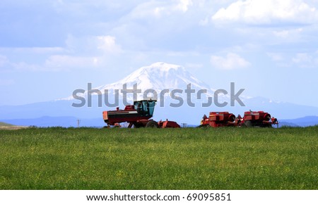 Farm machinery in a field & Mt. Adams.