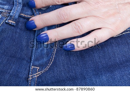 jeans and a female hand with blue nail polish