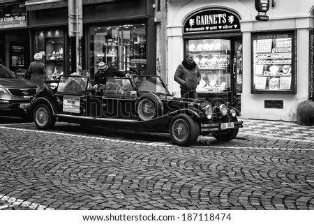 PRAGUE, CZECH REPUBLIC - FEBRUARY 02, 2014: Tour of the city on an old car. Black and white. Stylized film. Prague is the capital and largest city of the Czech Republic.