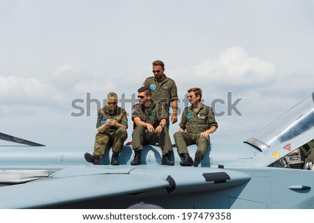 BERLIN, GERMANY - MAY 24, 2014: Pilots and technicians sitting on the aircraft fuselage Panavia Tornado. German Air Force. Exhibition ILA Berlin Air Show 2014