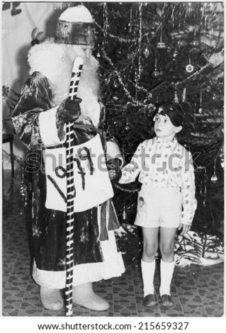 MOSCOW REGION, USSR - CIRCA 1978: Traditional children\'s party, New Year party in the kindergarten. Celebrated on the eve of the new year. Father Frost with a boy, circa 1978