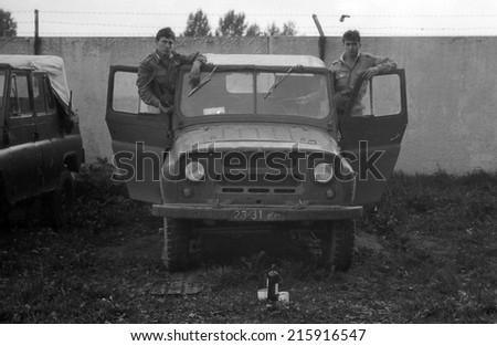 MOSCOW REGION, RUSSIA - CIRCA 1993: Two soldiers in the Army SUV UAZ-469. Film scan. Large grain, circa 1993