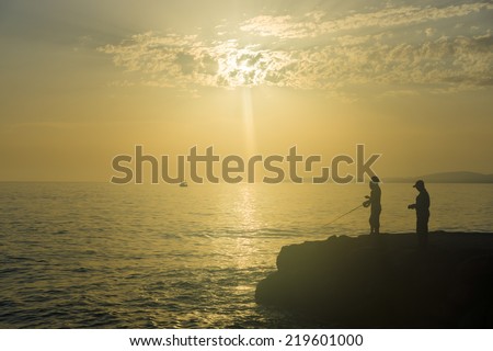Evening fishing on the Mediterranean Sea. Turkey. Silhouette of fishermen.