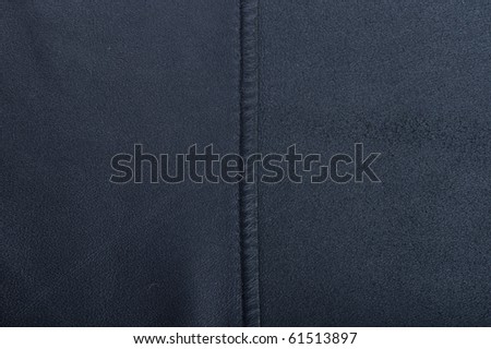 Fragment of a dark-blue leather with a suture.