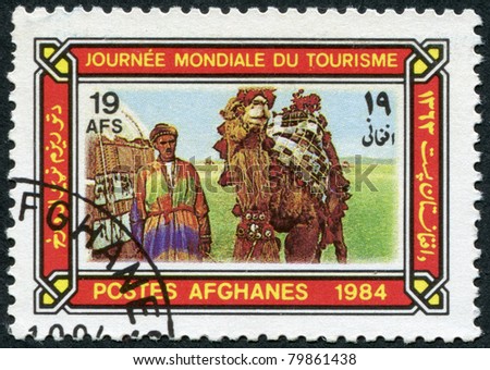 AFGHANISTAN - CIRCA 1984: A stamp printed in the Afghanistan devoted to World Tourism Day. Depicted Camel driver, tent, camel in caparison, circa 1984
