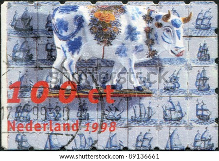 NETHERLANDS - CIRCA 1998: A stamp printed in the Netherlands, shows a Cow, tiles with pictures of sailing ships, circa 1998