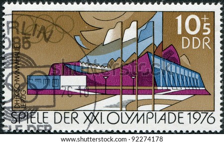 DDR - CIRCA 1976: A stamp printed in DDR, devoted to the Summer Olympics in Montreal, depicts Swimming pool, High School for Physical Education, Leipzig, circa 1976