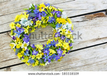 wreath made of fresh spring flowers on wood
