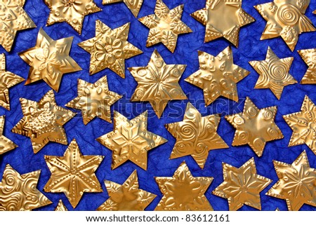 Handmade stars of gold foil an blue background