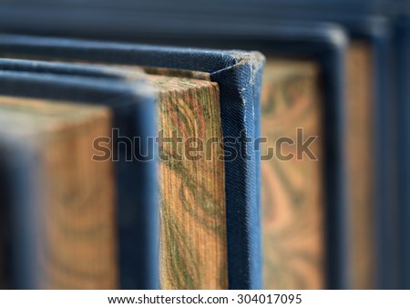 Front view of old books stacked on a shelf