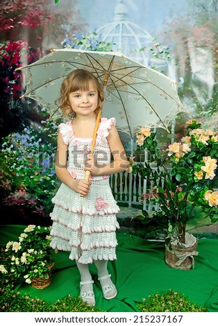 beautiful girl with an umbrella in the openwork knit dress on green background