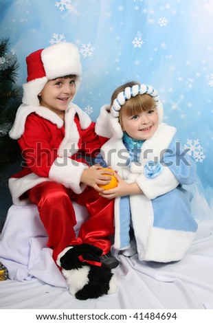 boy and girl in costume of Santa Claus and Snow Maiden about trees