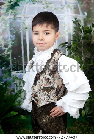 cute little boy dressed in a white blouse against the background of the garden