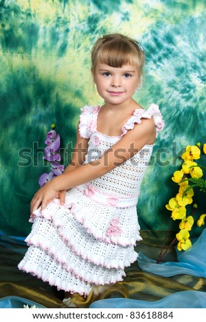 beautiful girl in knitted dress with a green background