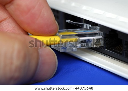 Plug the yellow network cable into the router isolated on blue