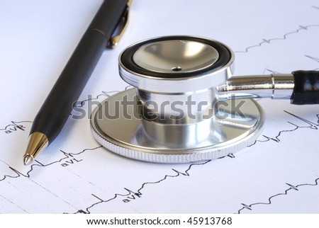 A stethoscope and a pen on the top of the EKG graph