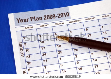 Planning the year on the day planner isolated on blue