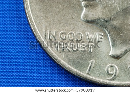 In God We Trust from the dollar coin isolated on blue