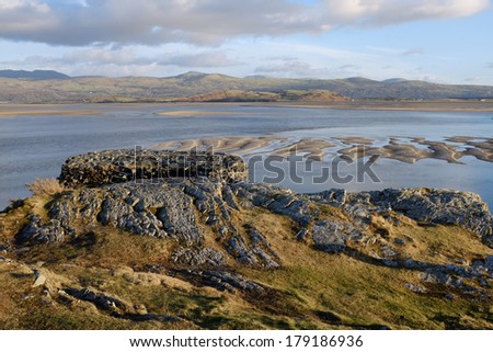 A flat topped view point looks out over an estuary and distant mountain range.