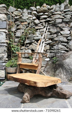 Hand made wooden garden furniture, chair and table, set on paving 