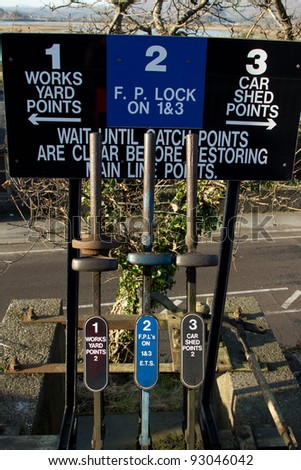 A vintage set of points levers for railway use with signs indicating their use.