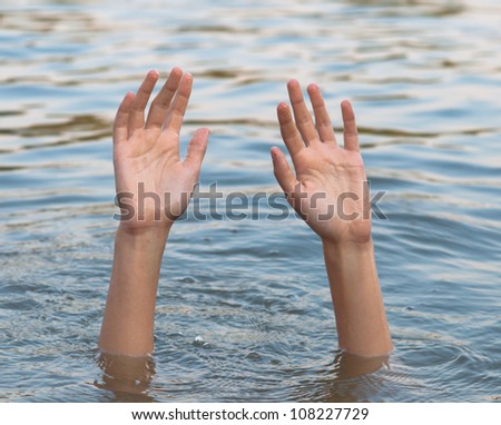 Female hands and arms protruding from the water surface.