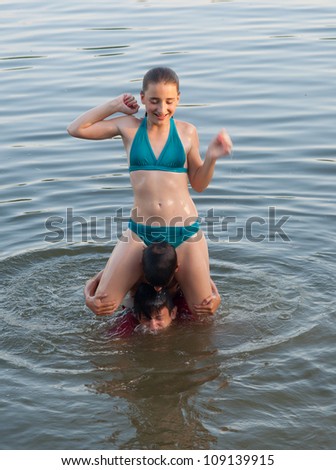 Cute teenage girl having fun with her friends in the river.