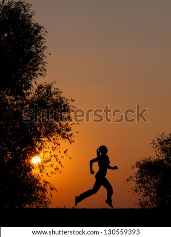 Silhouette of young woman running at summer sunset in the nature.