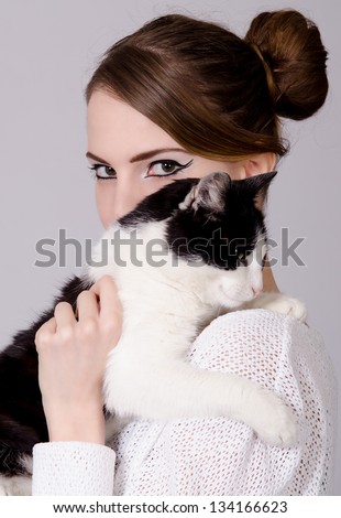 Elegant lady holding black and white cat.
