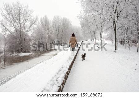 Teenage girl walking the dog on beautiful winter day.